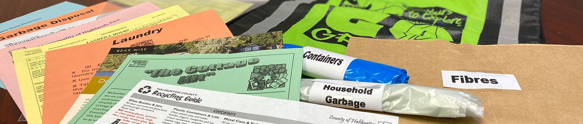 Contents of the Cottage Kit spread out on a table include garbage bags and various guides.