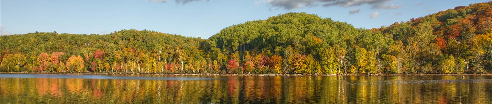 Dark Lake in Autumn with colourful hills in the background reflecting on the water.