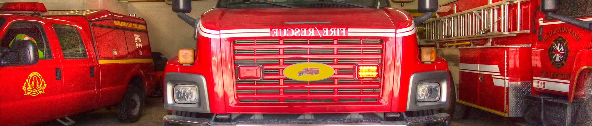 A close up shot of three Highlands East fire trucks parked in their garage.