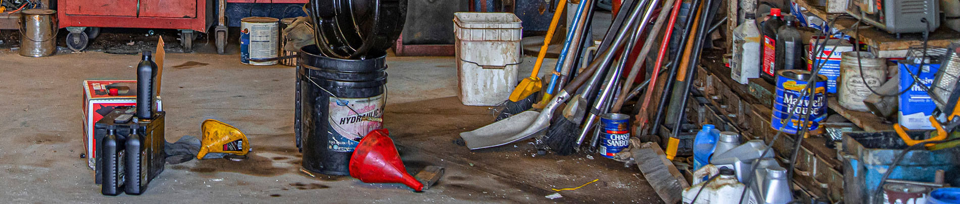 Many different types of hazardous waste pictured in someone's garage.