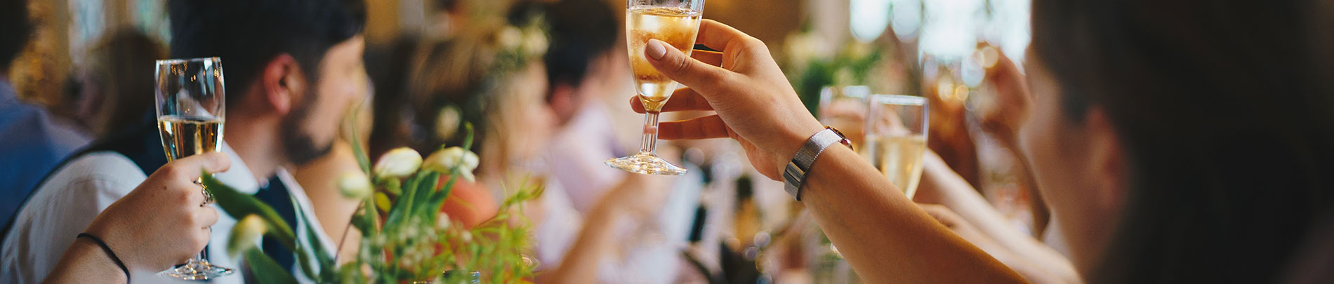 A group of people hold up their glasses for a toast.