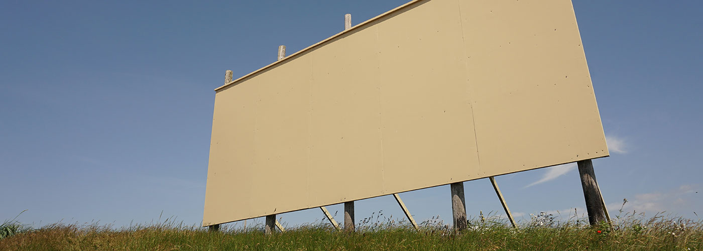 A blank billboard in a field.