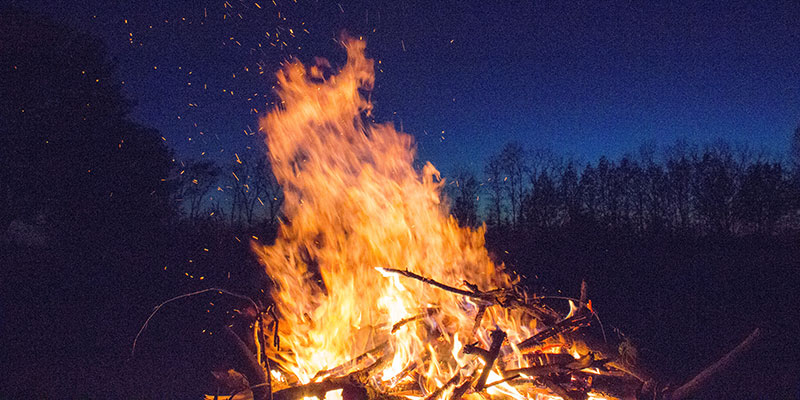 A large bonfire burns in the night.