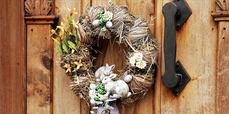 An easter wreath hangs on the outside of a door.
