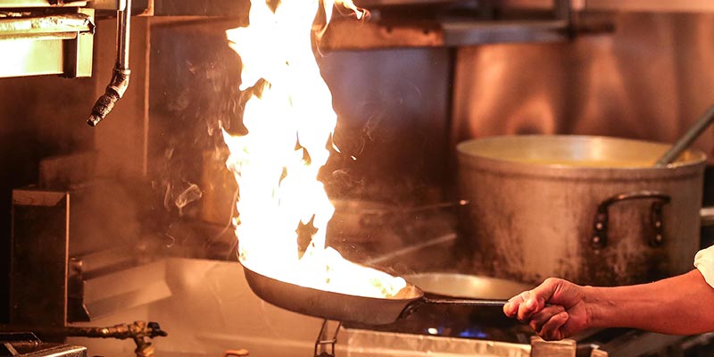 A flaming pan in the kitchen.