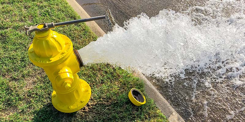 A yellow hydrant with water flowing out of it.
