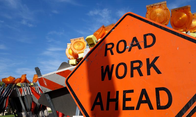 A road work ahead sign set up on a road.