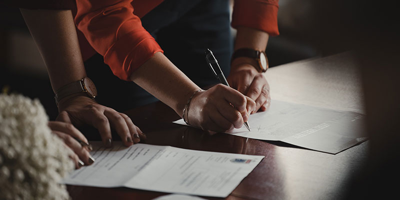 People signing papers at a table.