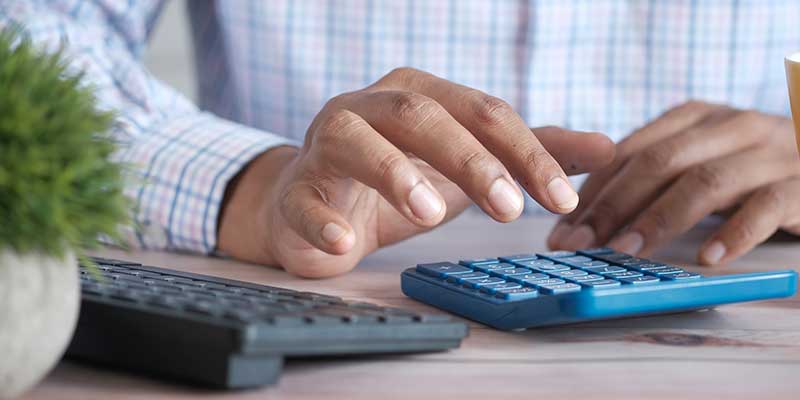 A person works with a calculator at a desk.